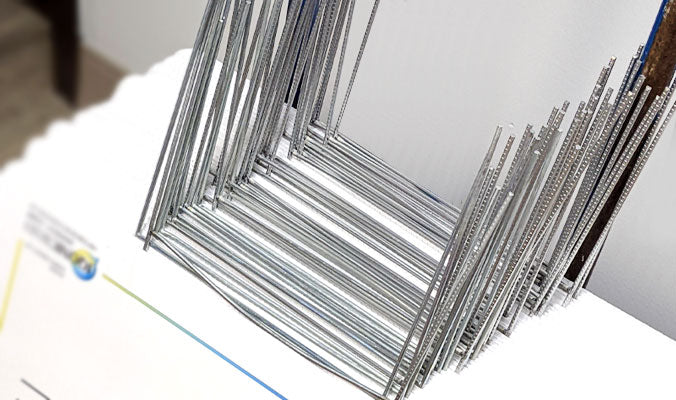 A metal frame with two prongs that are pushed into the ground, providing a sturdy base for the sign to stand upright.